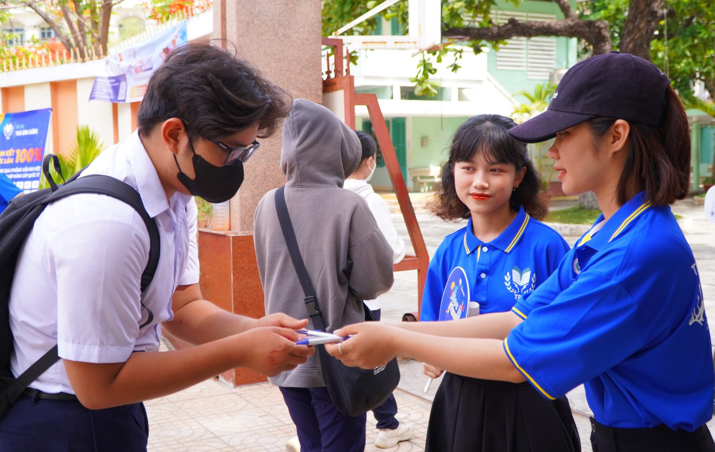 Các tình nguyện viên tặng bút cho thí sinh tại điểm thi ở TP Cam Ranh.
