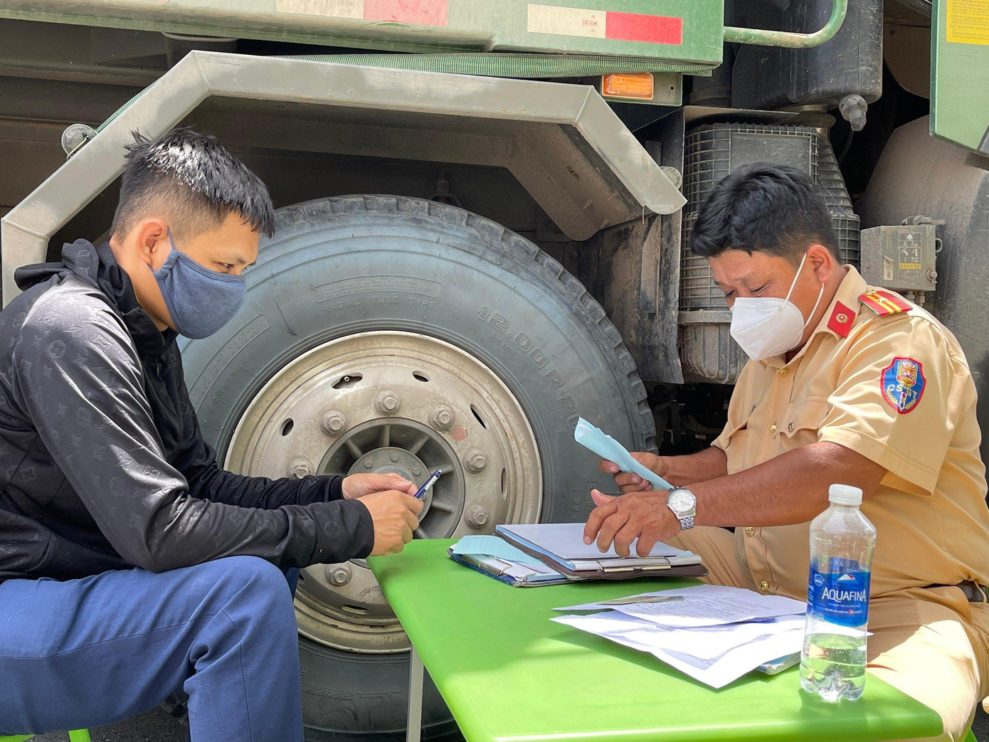 Cán bộ CSGT lập biên bản với tài xế và chủ phương tiện có hành vi cơi nới thùng hàng, chở hàng quá khổ, quá tải.