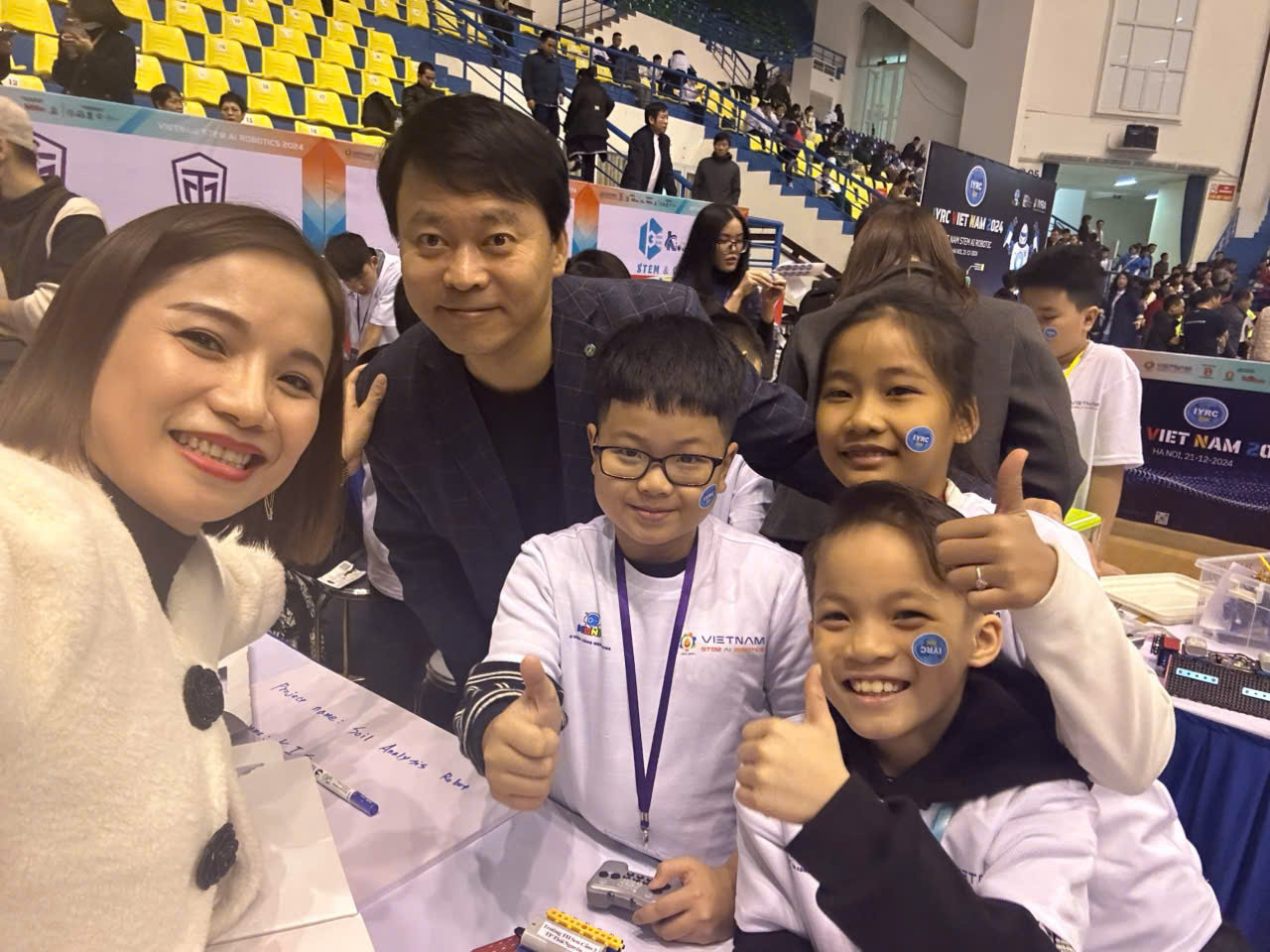 Cô Thu Hương - Hiệu trưởng trường Tiểu học Sơn Cẩm 3 (Thái Nguyên) cùng các em học sinh chụp ảnh lưu niệm với ông Harry Roh - Chủ tịch Hiệp hội robot Thanh thiếu niên Quốc tế - IYRA (International Youth Robot Association). Ảnh: NVCC