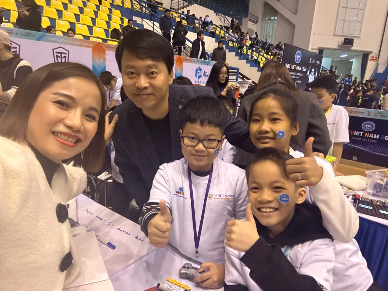 Cô Thu Hương - Hiệu trưởng trường Tiểu học Sơn Cẩm 3 (Thái Nguyên) cùng các em học sinh chụp ảnh lưu niệm với ông Harry Roh - Chủ tịch Hiệp hội robot Thanh thiếu niên Quốc tế - IYRA (International Youth Robot Association). Ảnh: NVCC