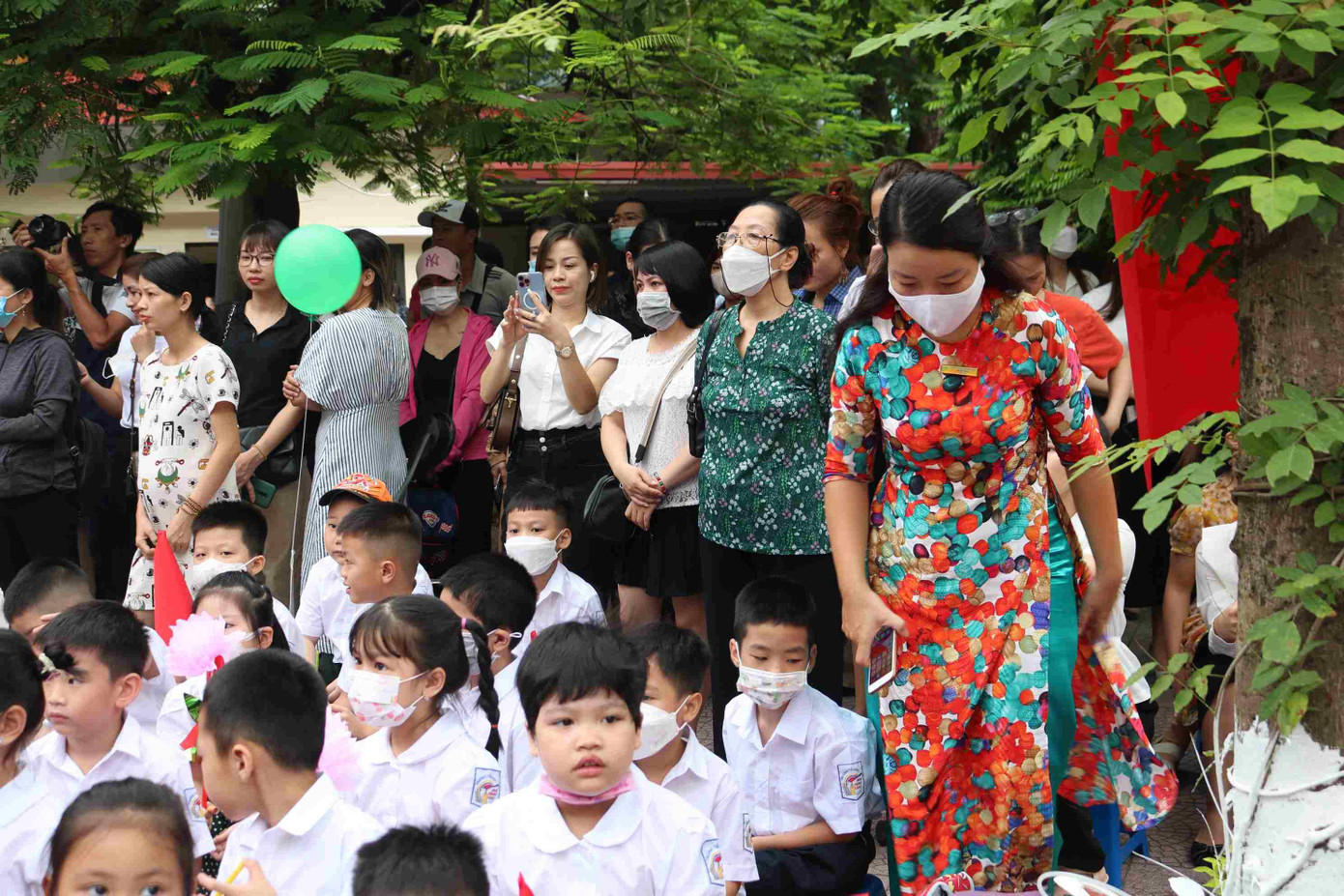 Nhiều bậc phụ huynh nán lại phía sau khu vực xếp hàng của học sinh để theo dõi lễ khai giảng. Nhiều bậc phụ huynh nán lại phía sau khu vực xếp hàng của học sinh để theo dõi lễ khai giảng.