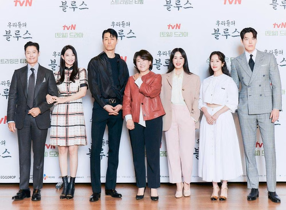 Dàn diễn viên của Our Blues tại họp báo ra mắt phim. Shin Min Ah và Kim Woo Bin chung khunh hình nhưng mỗi người một phương.