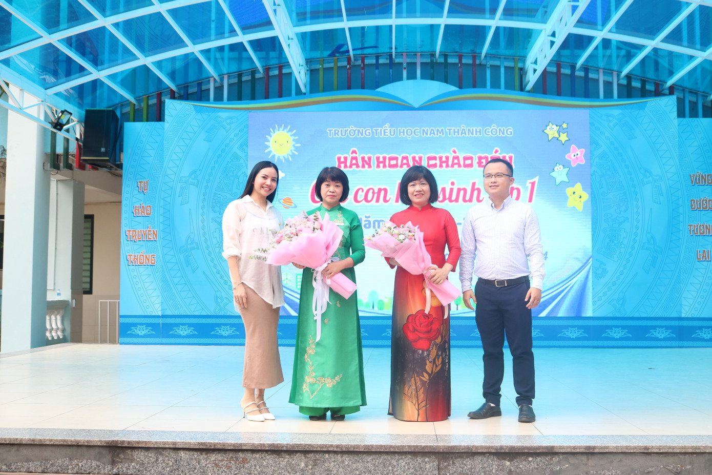 Đại diện hội phụ huynh khối lớp 1 và đại diện phụ huynh toàn trường tặng hoa chúc mừng tại buổi lễ.