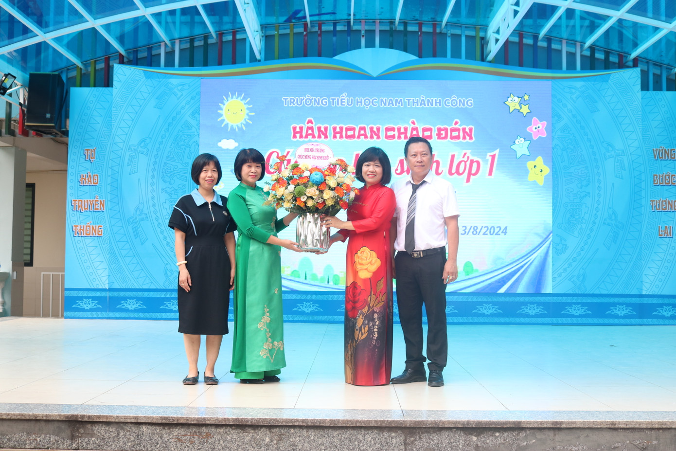 Đại diện hội phụ huynh khối lớp 1 và đại diện phụ huynh toàn trường tặng hoa chúc mừng tại buổi lễ.