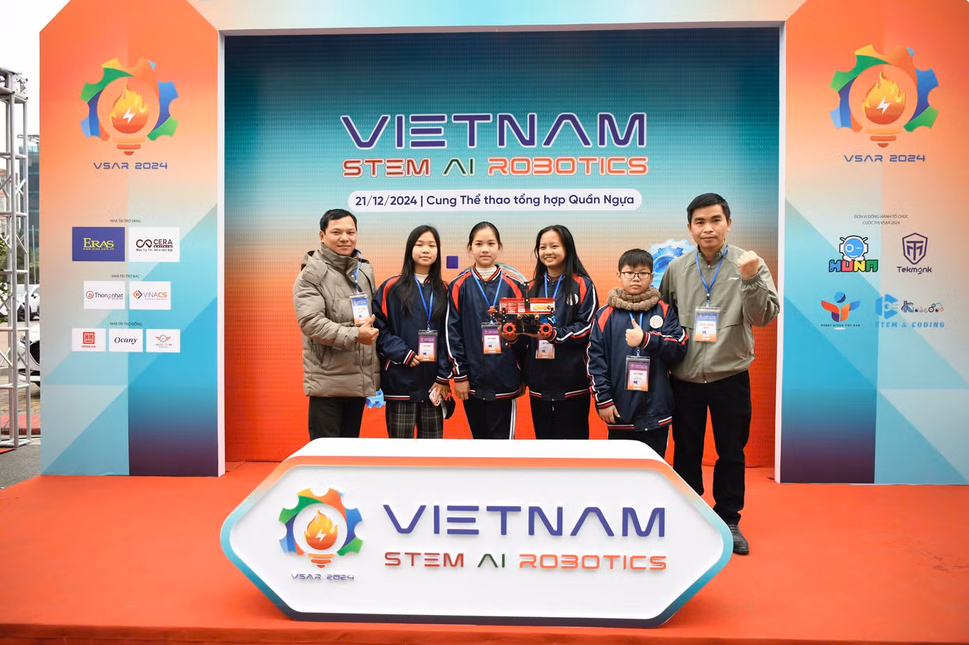Khu vực check-in ở bên ngoài sân thi đấu luôn nhộn nhịp thí sinh, thầy cô và phụ huynh ghé tới "thả dáng". Không ít đội thi tranh thủ thời gian nghỉ giữa trưa ra chụp ảnh kỷ niệm.