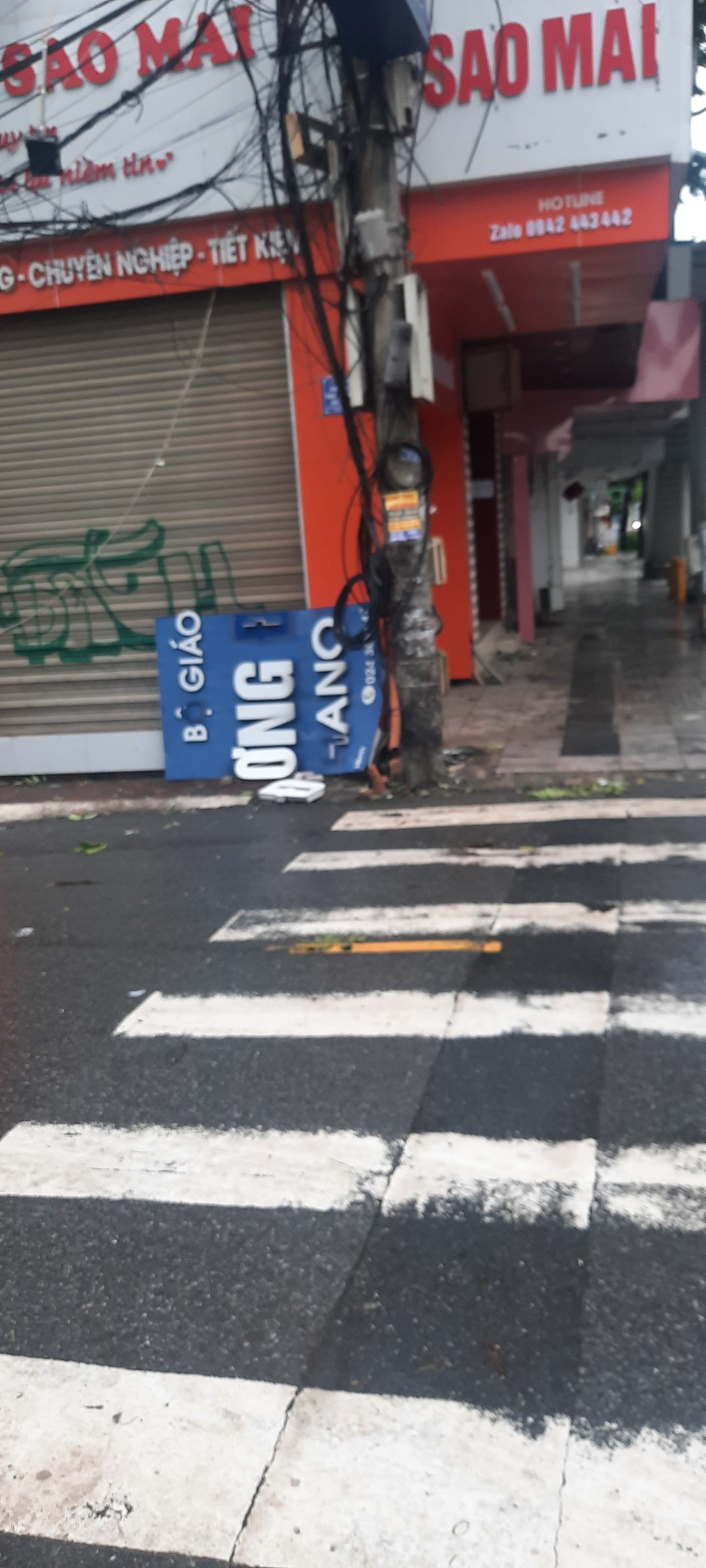 Một mảng của tấm biển trường HANU bị rơi xuống khu vực gần đó. - Ảnh: hackluv9229 Một mảng của tấm biển trường HANU bị rơi xuống khu vực gần đó. - Ảnh: hackluv9229