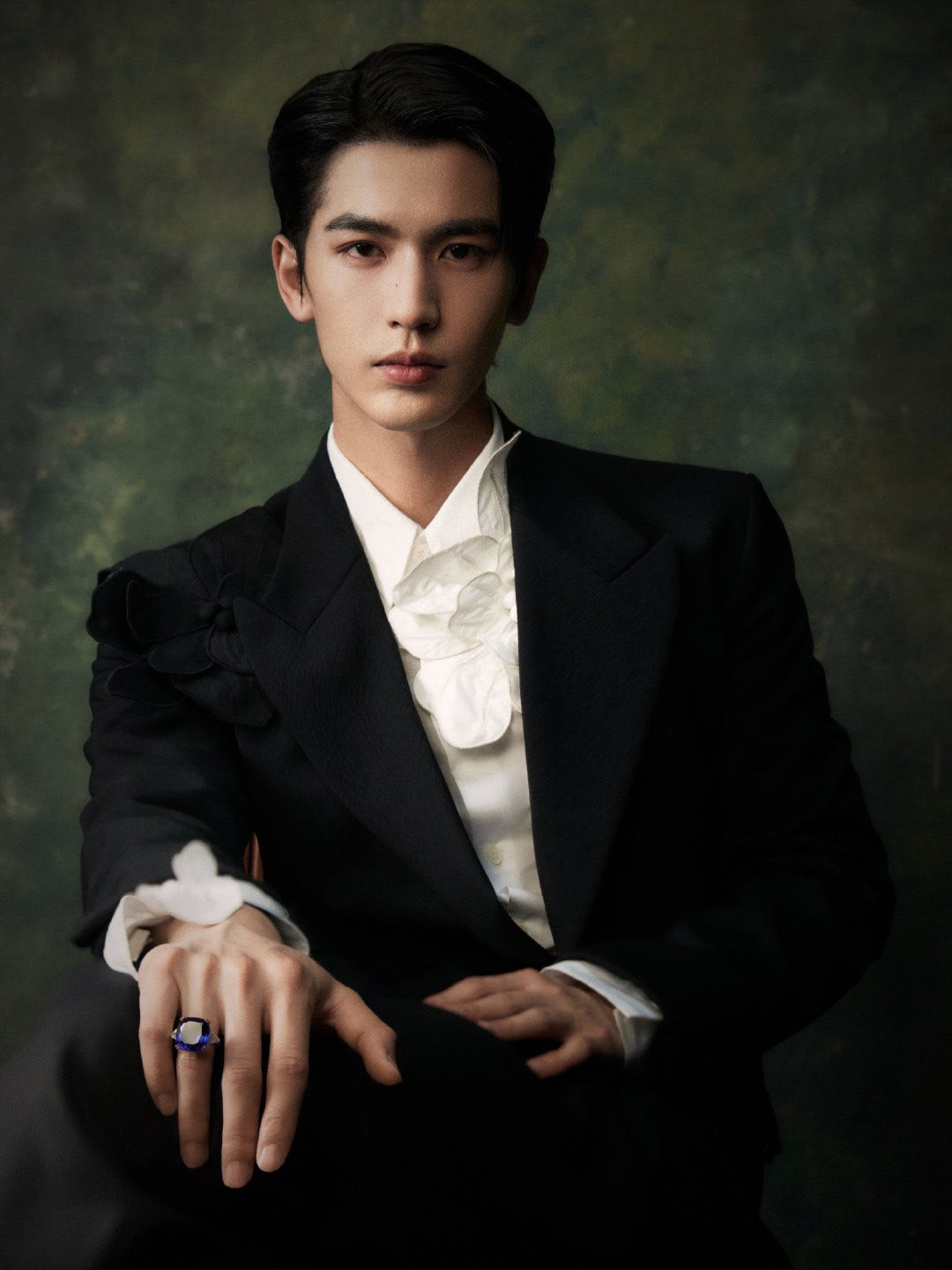 Lễ phục của Trương Lăng Hách đến từ thương hiệu Wooyoungmi, chiếc nhẫn đá xanh lấp lánh trên tay anh là của Chopard.