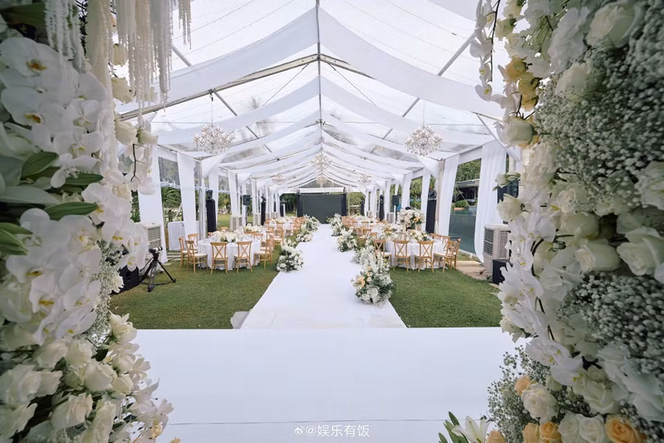 Lễ đường được bao phủ bởi tông trắng, dùng hoa hồng trắng, vàng và hoa lan để trang trí.