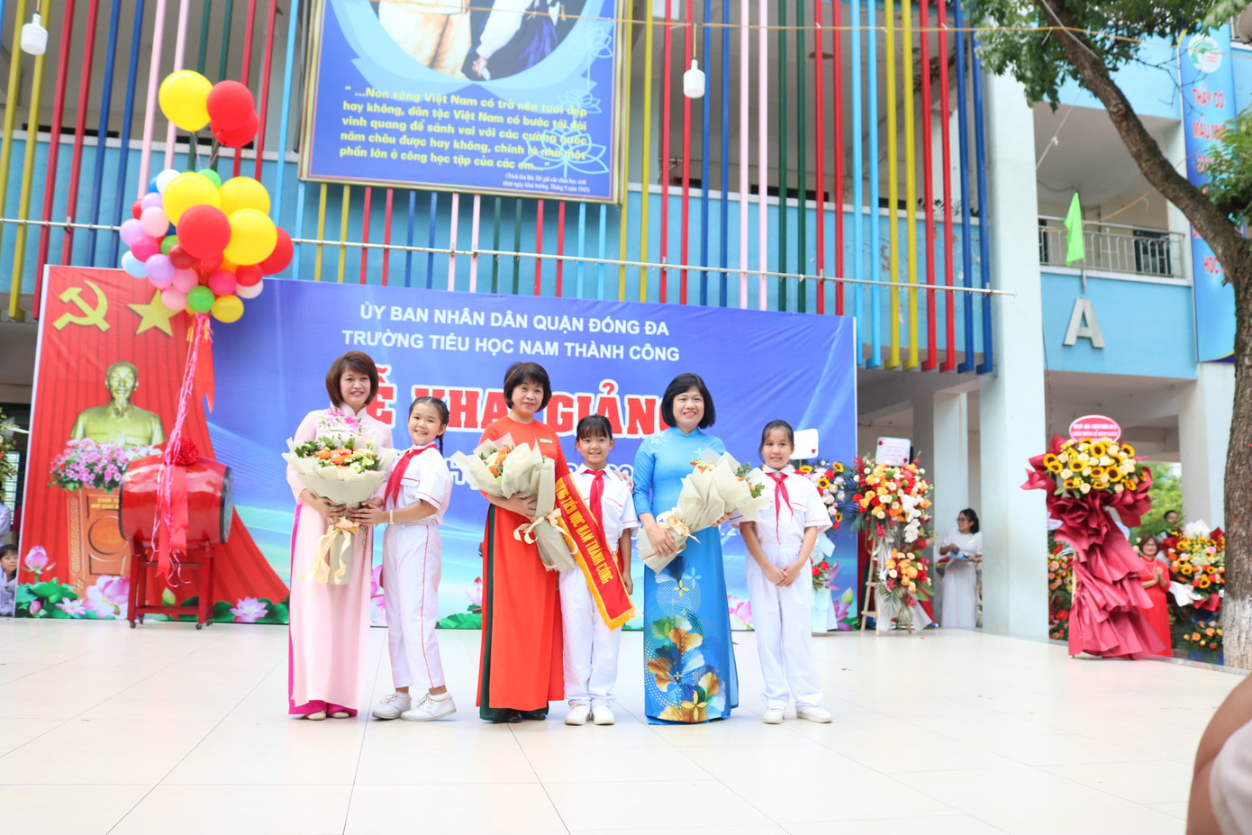 Ban giám hiệu nhà trường nhận hoa từ các đại biểu và đại diện các bạn học sinh.