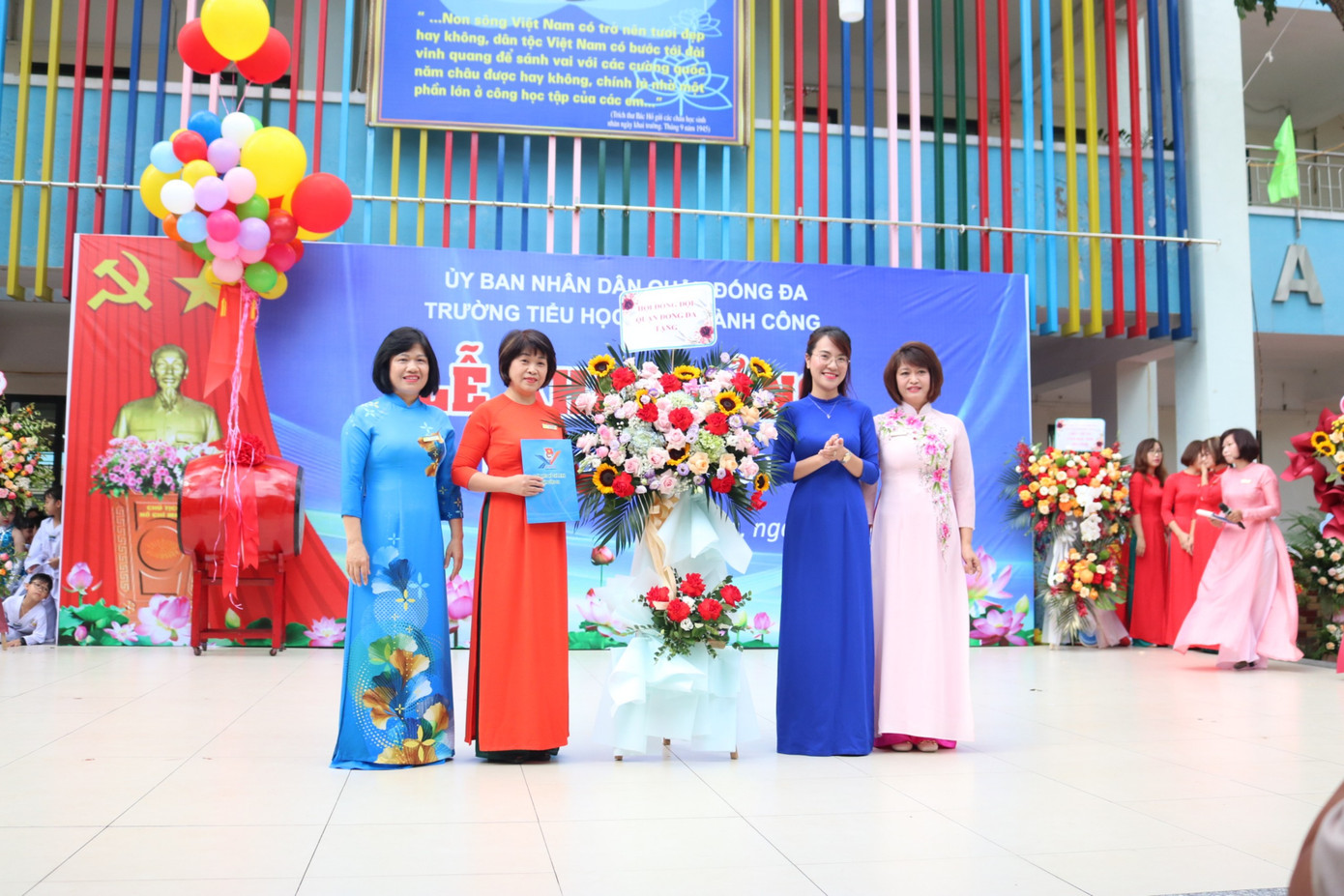 Ban giám hiệu nhà trường nhận hoa từ các đại biểu và đại diện các bạn học sinh.