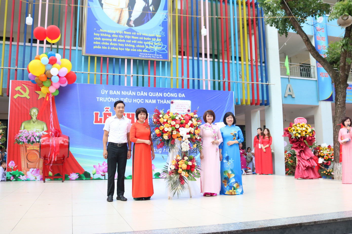 Ban giám hiệu nhà trường nhận hoa từ các đại biểu và đại diện các bạn học sinh.