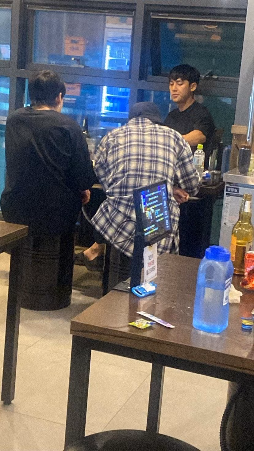 Bức ảnh chứng minh được cô bạn chia sẻ, do một bạn làm cùng chụp lại. Mingyu mặc áo đen ngồi trong một mình, Jung Kook mặc áo đen, quay lưng và Cha Eun Woo mặc sơmi caro.