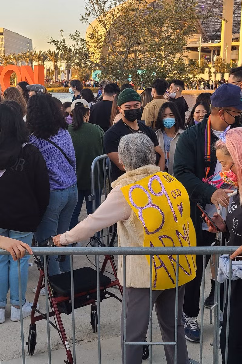 Sau lưng vị fan đặc biệt này là một tấm biển lớn ghi "89 years old, ARMY" (tạm dịch: ARMY 89 tuổi). Không phân biệt giới tính hay tuổi tác, ai cũng có quyền theo đuổi thần tượng của chính bản thân.