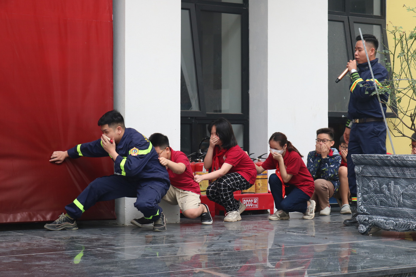 Các bạn nhỏ được chọn để lên sân khấu &quot;thị phạm&quot; trước toàn trường cách thoát hiểm khỏi phòng có khói khí độc.