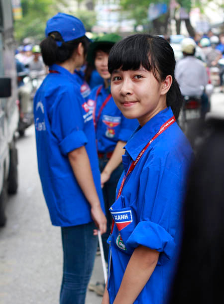 Các nữ tình nguyện viên trường ĐH Ngoại Thương Hà Nội phân luồng giao thông trước cổng trường thuộc phố Chùa Láng 