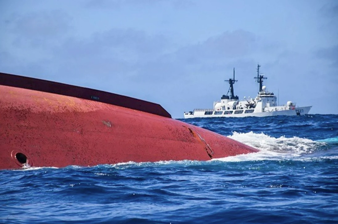 Con tàu vỏ đỏ lật úp trên biển.