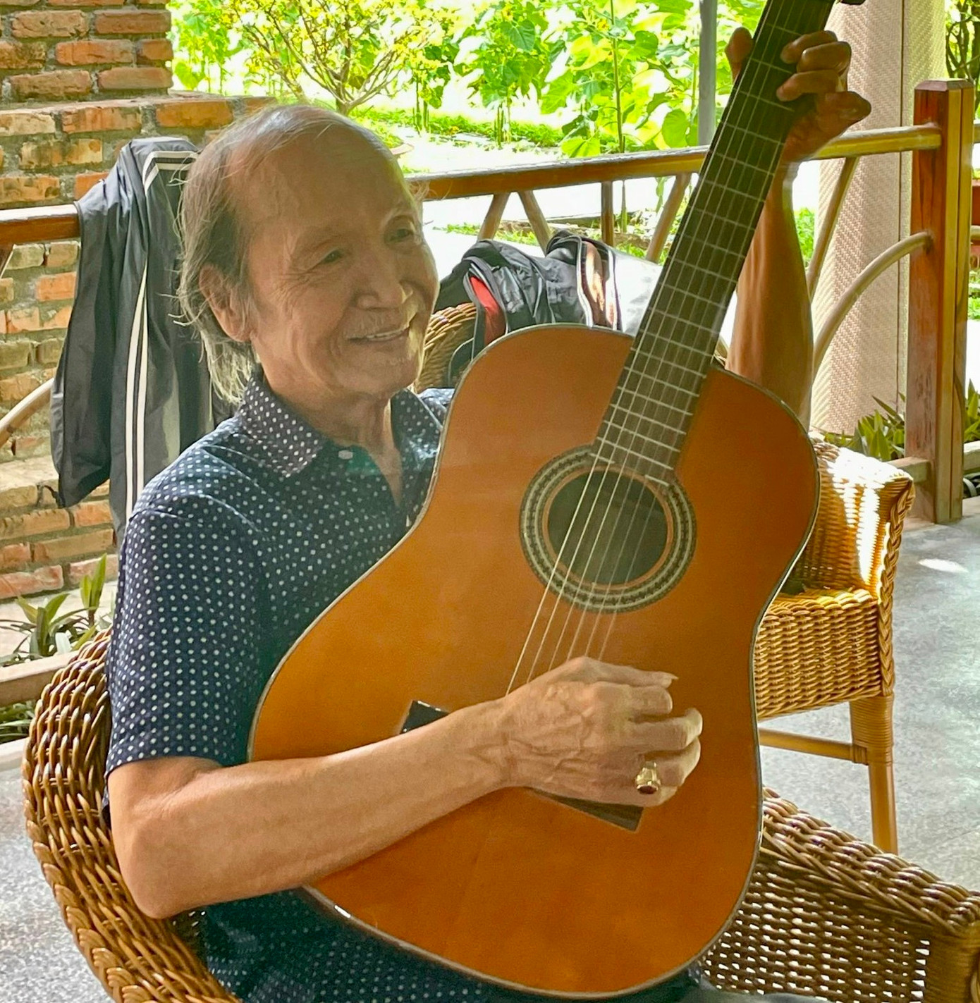 Ông Quý vui vẻ trò chuyện, chia sẻ về niềm đam mê làm đàn guitar với du khách.