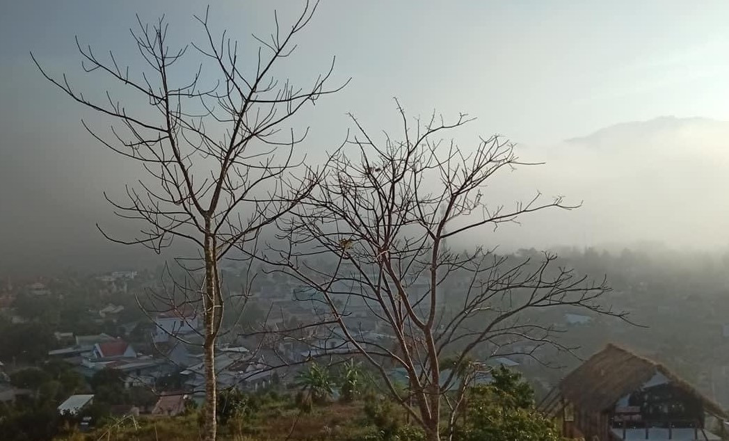 Những tia sáng xuyên qua màn mây dày làm lộ dần cảnh sớm của làng quê dưới chân núi.