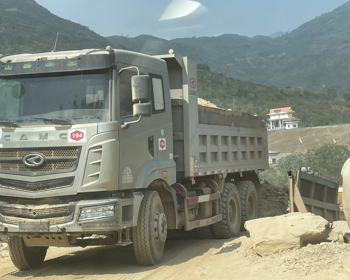 Xe tải không biển kiểm soát gắn logo Công ty 94 chở vật liệu thi công cao tốc.