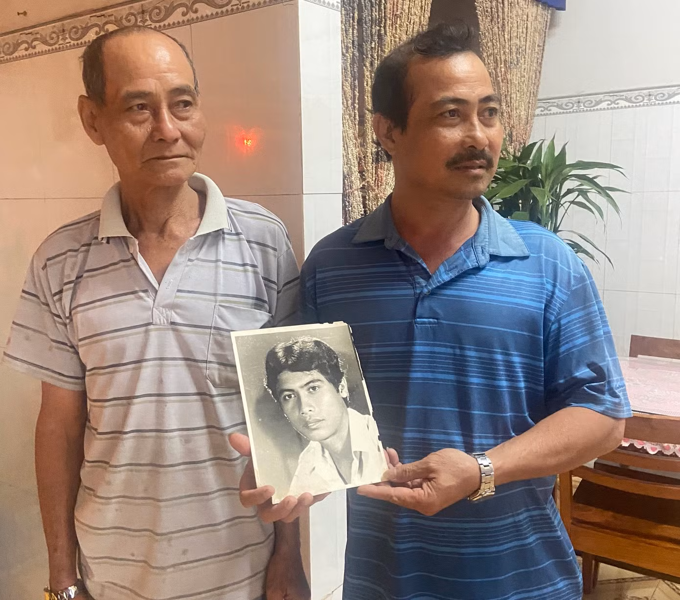 Anh Võ Đình Dũng (áo xanh) với di ảnh người anh - Liệt sĩ Võ Đình Tuấn (ảnh: K.N).