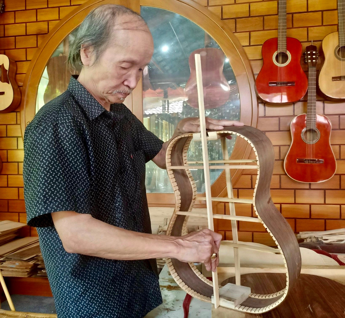 Nghệ nhân Lưu Hoàng Quý đang chế tác một cây đàn guitar.