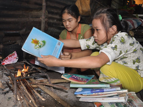 Hai em học sinh Phạm Thị Yến Nhi và Võ Thị Thùy Linh hơ sách sau ngày lũ 