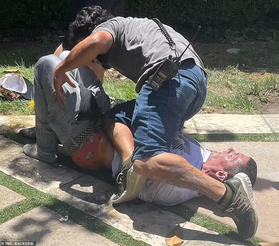 Jason Alexander bị nhân viên an ninh khống chế.