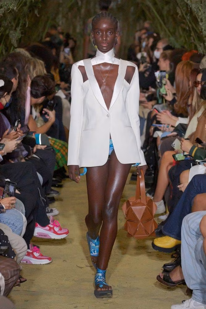 Một người mẫu da màu sải bước catwalk cho Coperni. Một người mẫu da màu sải bước catwalk cho Coperni.