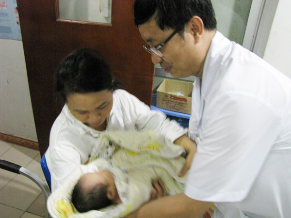 Sau khi hồi sức cấp cứu, chị Thơm được bác sỹ dẫn xuống Khoa Sơ sinh để gặp gon. Ảnh: Lãng Phong