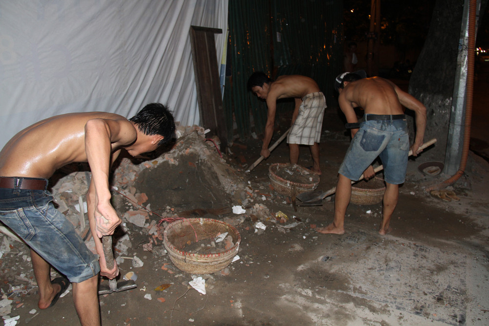 Gần 23 giờ, ba nam thanh niên bắt đầu công việc đội phế thải thuê trên phố Nguyễn Du (Hà Nội). Ảnh: Trường Phong