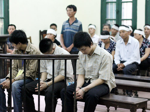 Bị cáo Sơn ngoài cùng bên phải cúi mặt tại phiên tòa. Bị cáo cúi mặt tại phiên tòa