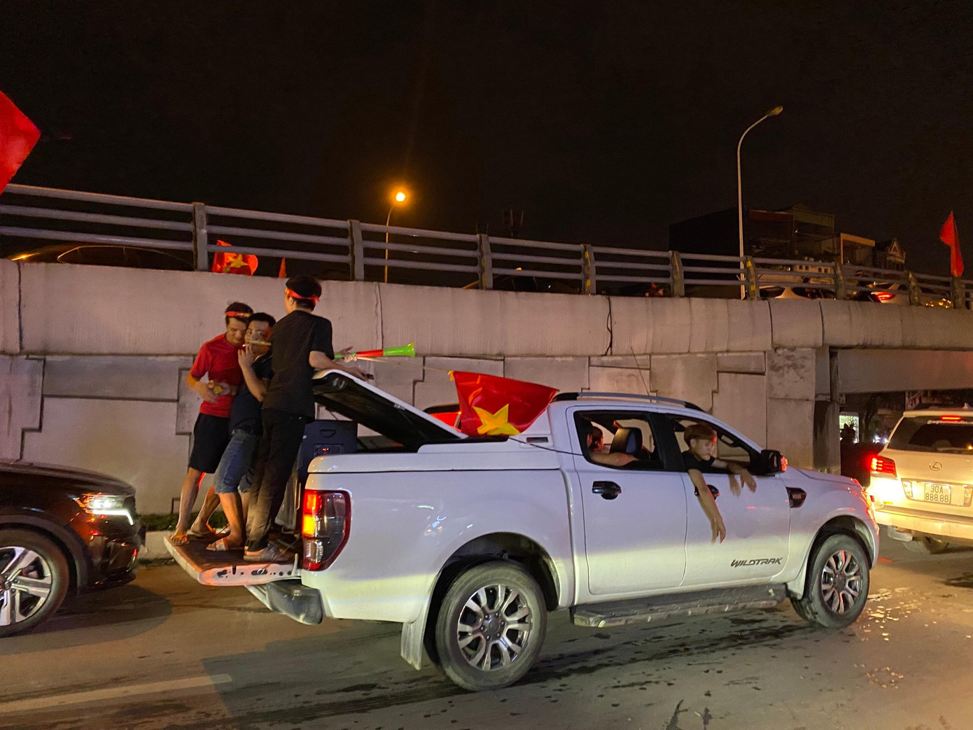 Nếu không ở nóc xe thì một số cổ động viên lại lựa chọn phần cửa thùng xe bán tải để đứng.