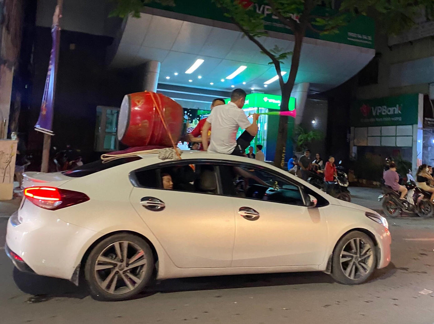 Trèo lên nóc xe ngồi và trên nóc còn buộc thêm cả trống.