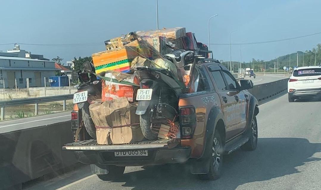Tài xế mang theo hai chiếc xe máy và hàng loạt thùng đồ được xếp từ thùng xe lên nóc xe, cố định bằng nhiều lần buộc dây. Tuy nhiên, chủ xe cũng phải lái rất cẩn thận để hàng hóa không bị rơi ra ngoài.
