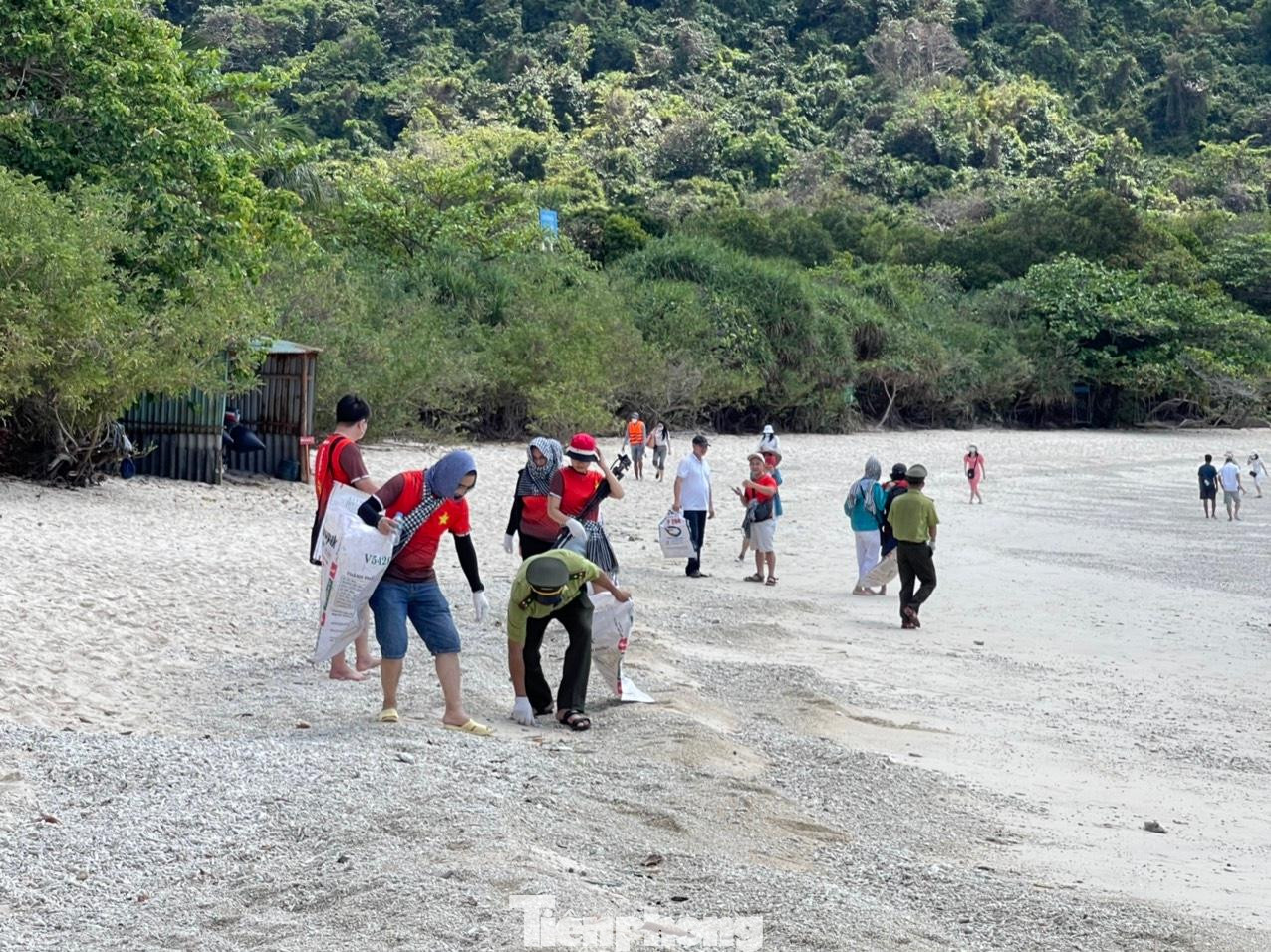 Các cán bộ, phóng viên của báo Tiền Phong và các kiểm lâm viên của trạm Kiểm lâm Hòn Bảy Cạnh cùng nhau dọn rác, làm sạch bãi biển.