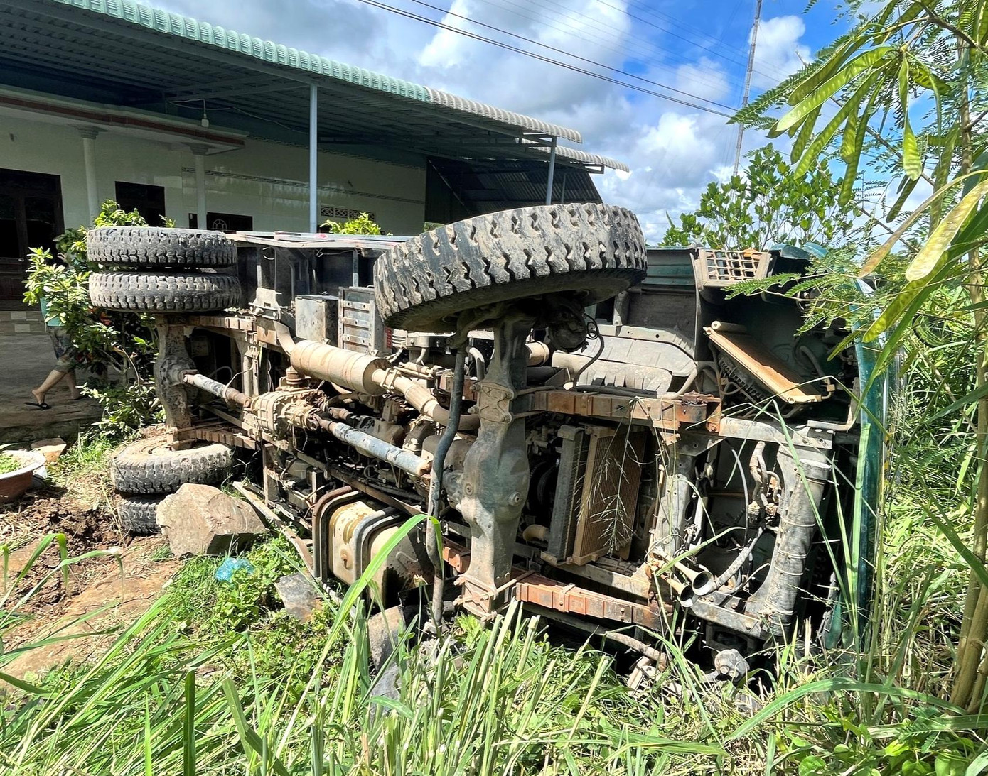 Xe ben văng vào trước nhà dân sau khi vụ tai nạn với tàu hỏa.