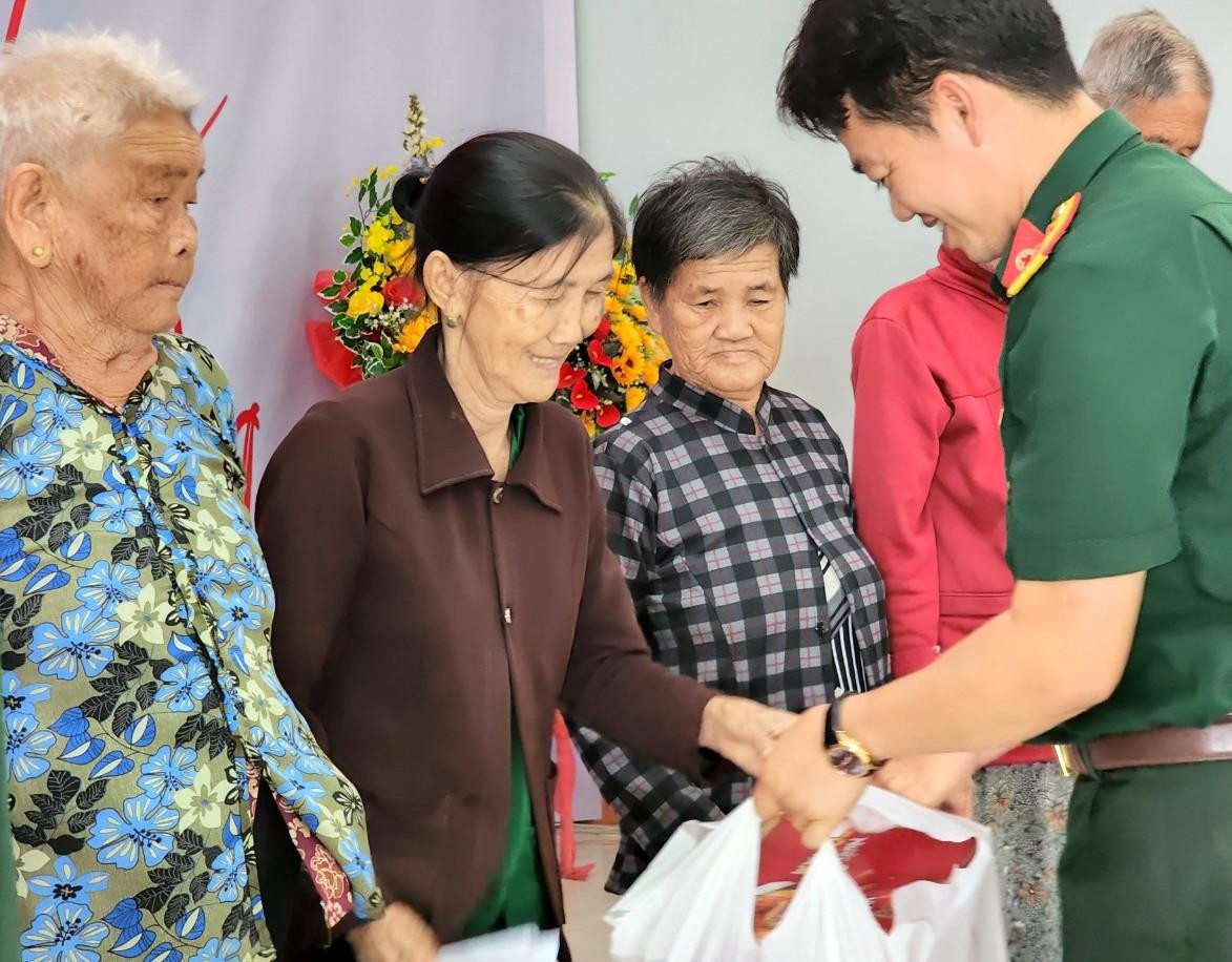 Trung tá Vũ Sơn Giang, Phó Chủ nhiệm Chính trị Bệnh viện Quân Y 175 tặng quà cho gia đình chính sách, người có công ở xã Tân Thành.