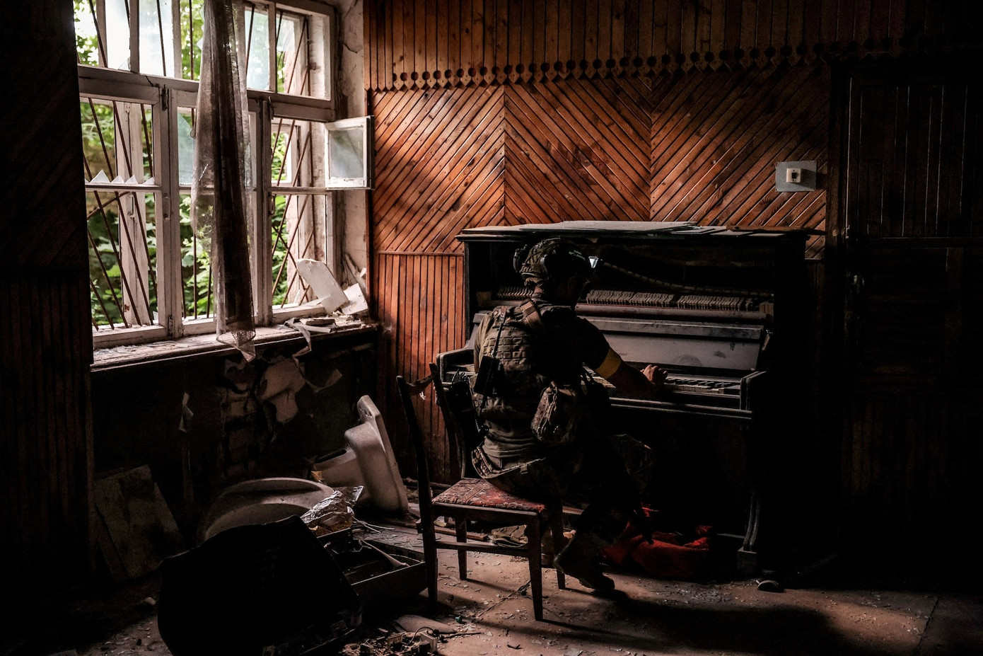 Một quân nhân Ukraine chơi đàn piano trong căn nhà bị phá hủy ở thị trấn tiền tuyến Chasiv Yar (Donetsk) tháng 6/2024. (Ảnh: Quân đội Ukraine)