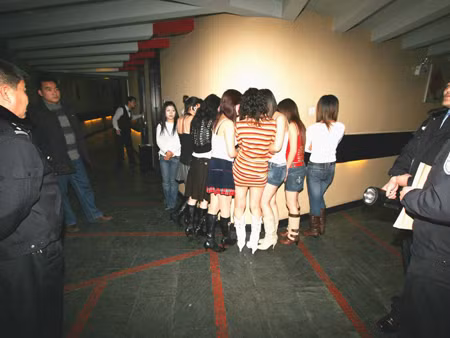 Một nhóm nữ giới bị cảnh sát Trung Quốc bắt giữ ở một quán karaok. Ảnh: AP