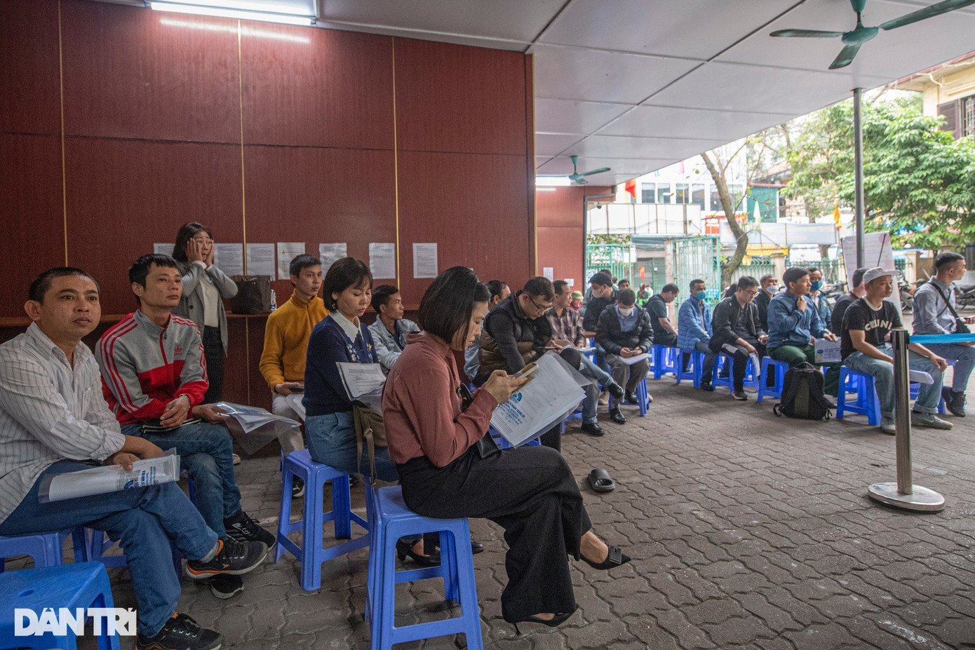 Để người dân xếp hàng trật tự, an toàn, anh Vũ Thái Hiên, nhân viên bảo vệ, phải liên tục nhắc nhở, hướng dẫn mọi người xếp hàng theo thứ tự, chuẩn bị sẵn hồ sơ cầm trên tay.