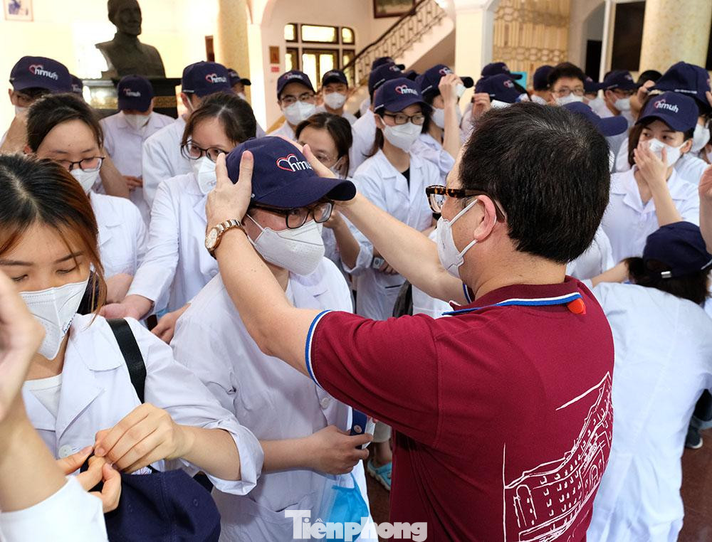 Phát biểu tại Lễ ra quân đợt 2, GS.TS Tạ Thành Văn - Chủ tịch Hội đồng trường cho biết: &quot;Trong đợt ra quân trước, 40 cán bộ và sinh viên Nhà trường tình nguyện chi viện cho Bắc Ninh được đánh giá rất cao trong việc phối hợp với nhân viên y tế địa phương trong công tác phòng chống dịch. Nhà trường hy vọng cán bộ và các em sinh viên tiếp tục sẽ nỗ lực hết mình, góp một phần sức lực nhỏ bé của mình trong cuộc chiến chống dịch của cả nước&quot;. Trong ảnh, GS Văn đang đội mũ cho những sinh viên tình nguyện lên đường chống dịch COVID-19.