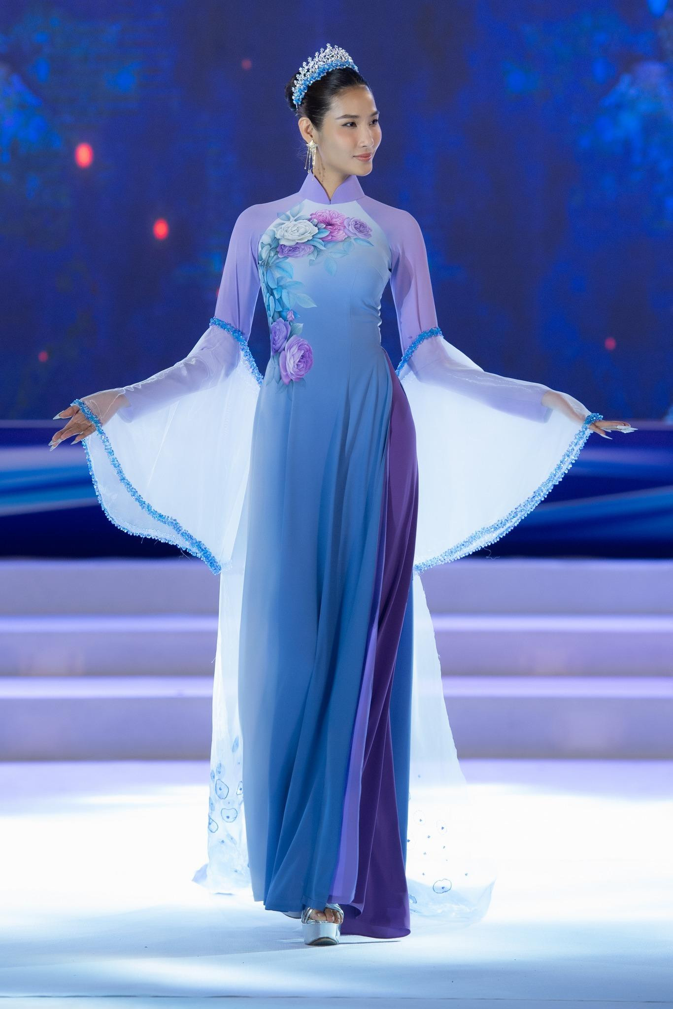 Á hậu Hoàng Thuỳ duyên dáng, thướt tha khi trình diễn áo dài trên sàn catwalk.