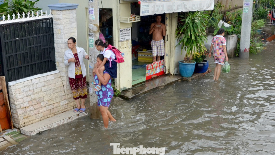 Học sinh xắn quần lội nước đến trường ngày đầu tuần vì triều cường gây ngập ảnh 7