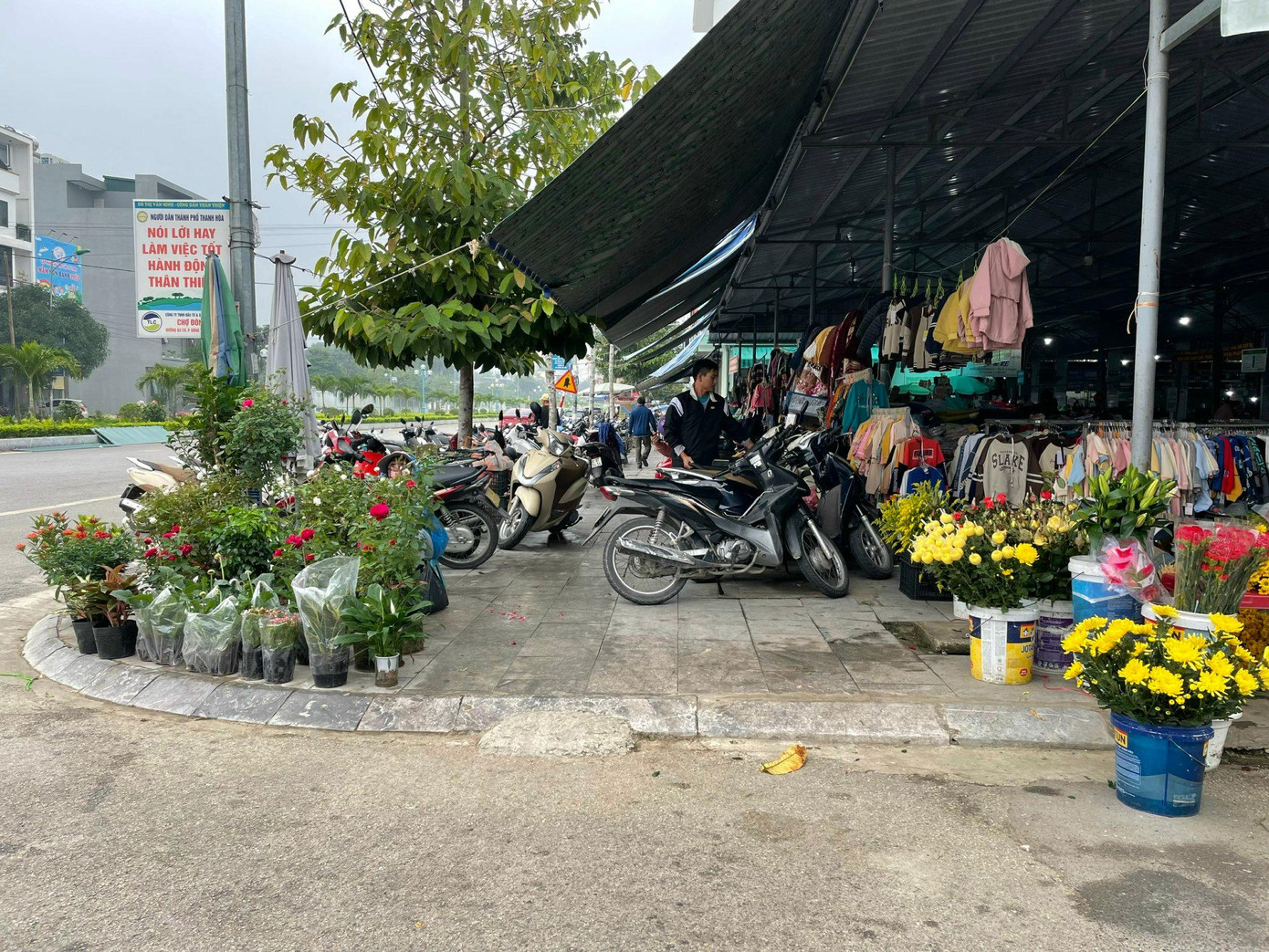 Vỉa hè của phía Tây chợ Đông vệ (tuyến đường 39 m- đường Âu Cơ) thành nơi bán hàng, thu phí xe máy của người đi chợ.