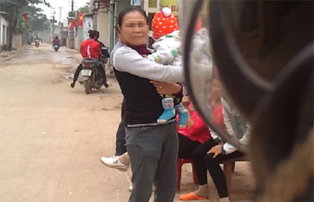 Bà mẹ của chủ quán D.T trên tay bế đứa cháu nhỏ cũng chạy ra chèo kéo khách.Ảnh cắt từ clip Bà mẹ của chủ quán D.T trên tay bế đứa cháu nhỏ cũng chạy ra chèo kéo khách