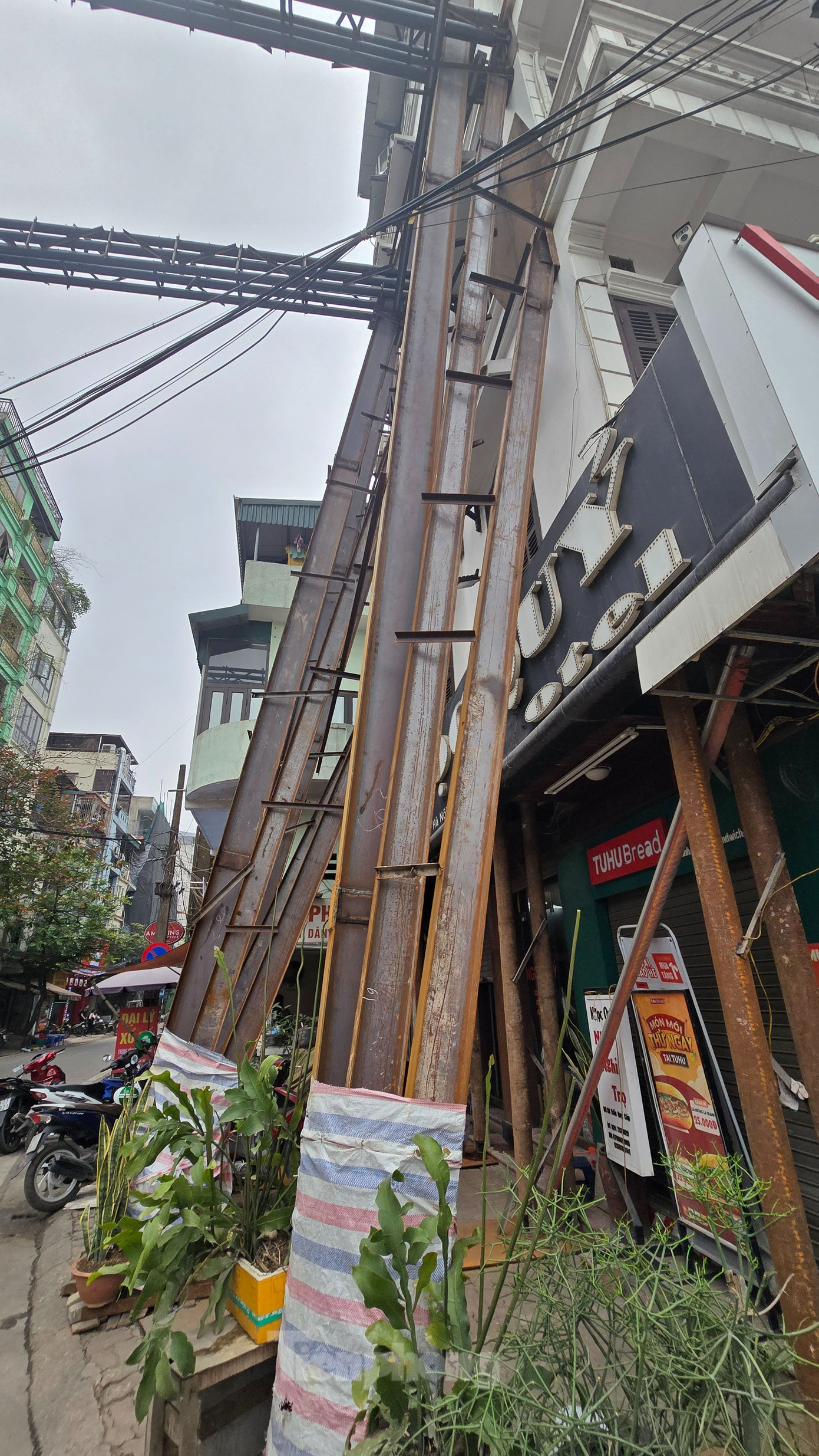 Người dân cho biết, khoảng gần 1 tháng nay, cột sắt được dựng lên để gia cố căn nhà số 50 Trần Quý Cáp. Từ ngày 6/4, khung thép cỡ lớn được vắt ngang sang hai bên đường để gia cố cho căn nhà.