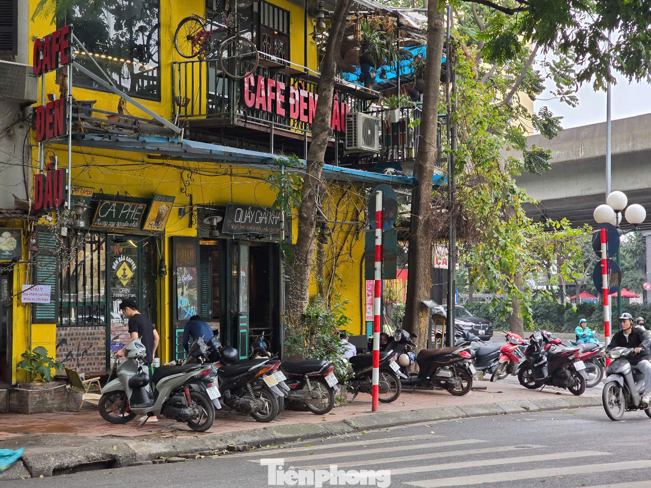 Vỉa hè đoạn trước quán cafe Đèn Dầu phố Ngụy Như Kom Tum bị chiếm dụng làm chỗ để xe máy và bàn cho khách.