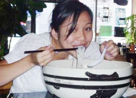 Một cô gái tham gia thi ăn phở. Ảnh: Phở Garden