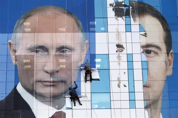 Tấm áp phích khổng lồ về chân dung tổng thống Nga Dmitry Medvedev và thủ tướng Nga Vladimir Puti đang được người công nhân hoàn thiện bên ngoài một tòa nhà. Đây là hoạt động trước thềm bầu cử sẽ diễn ra vào 4-12 sắp tới