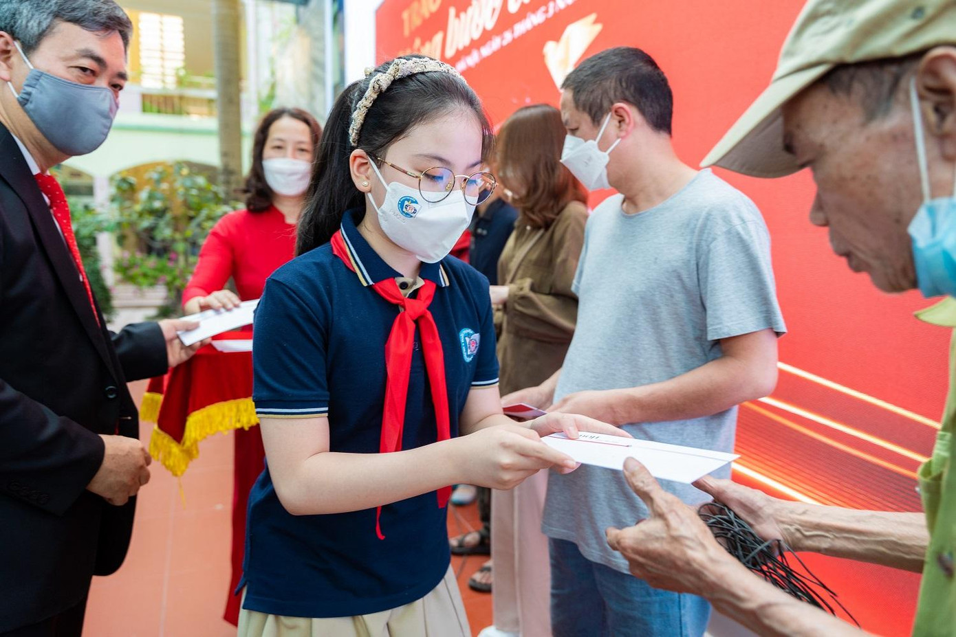 Em Đặng Vũ Hà Châu, lớp 5A6 trường Tiểu học Đoàn Thị Điểm trao quà cho các hộ dân bị ảnh hưởng bởi dịch COVID-19 quận Ba Đình.